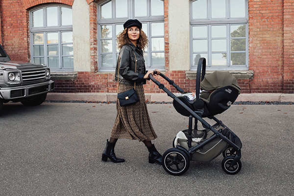 Stylowy fotelik BeSafe na stelażu wózka w miejskiej przestrzeni – wygodne przenoszenie niemowlęcia i bezpieczne mocowanie podczas spaceru